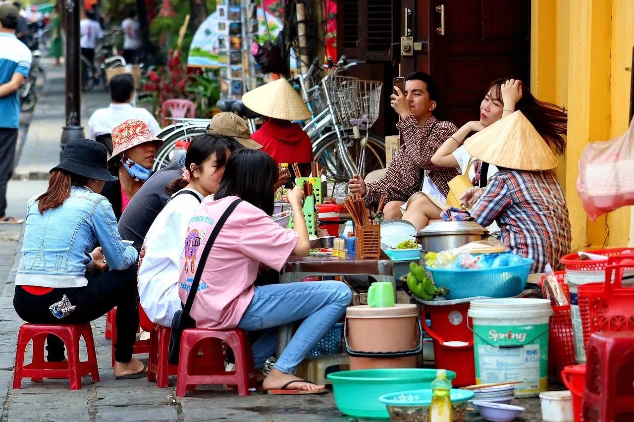 Quán ăn vỉa hè đông khách với ghế nhựa nhỏ