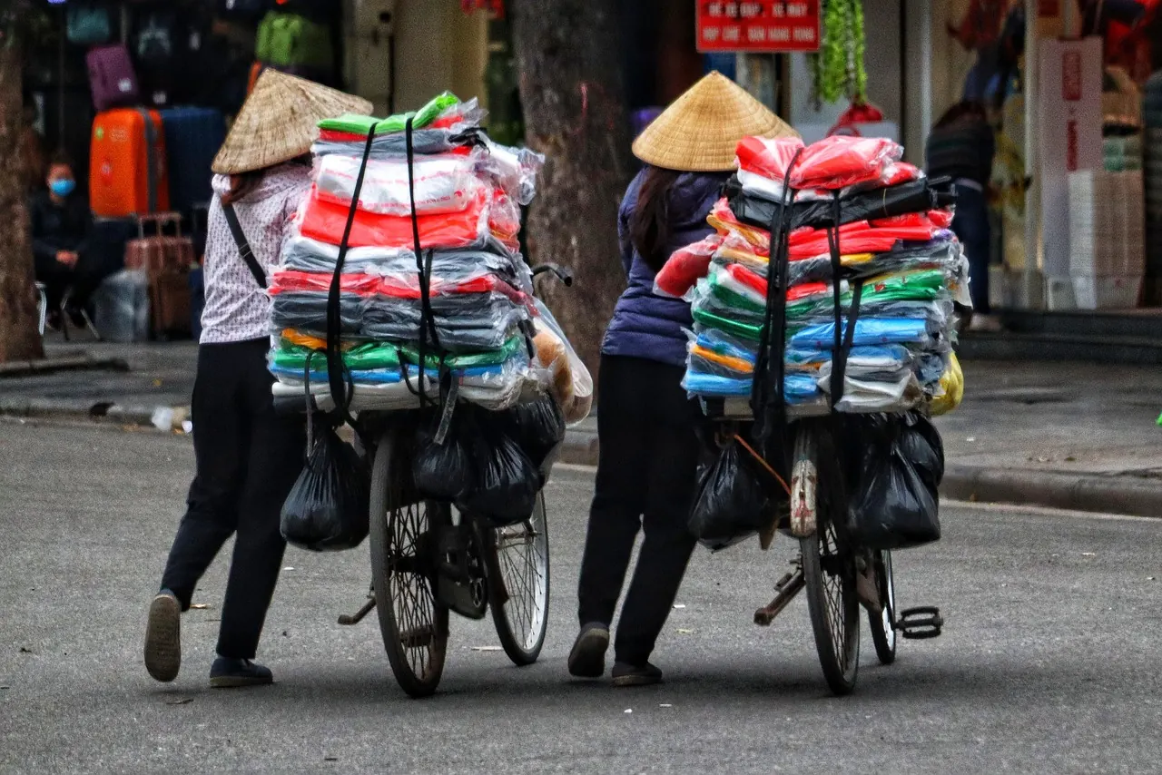 Người bán hàng rong dắt xe đạp chở đầy hàng hóa