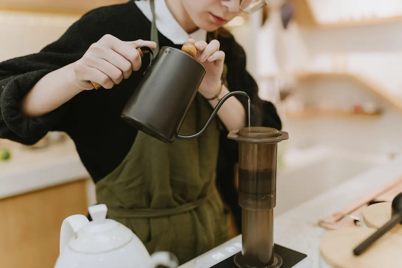 Nhân viên pha chế rót nước pha cà phê thủ công