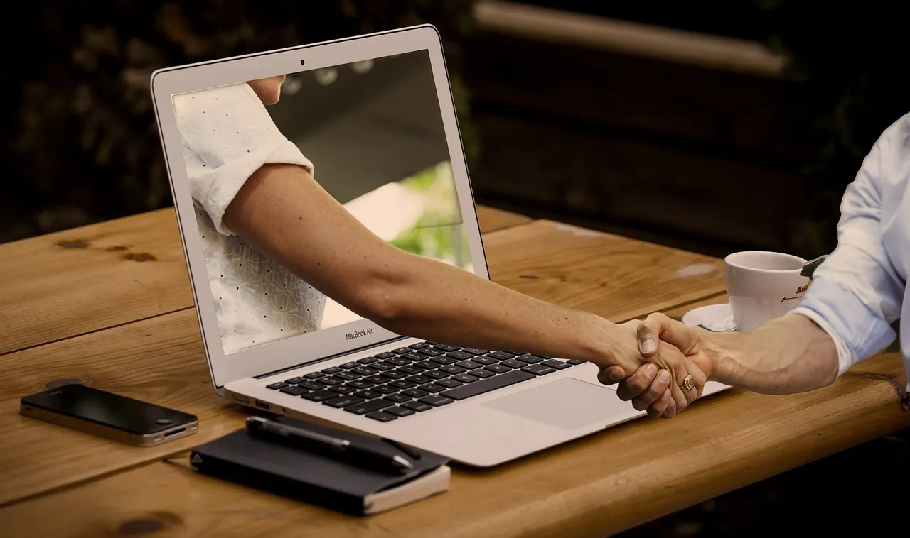 Bắt tay bên bàn làm việc có laptop