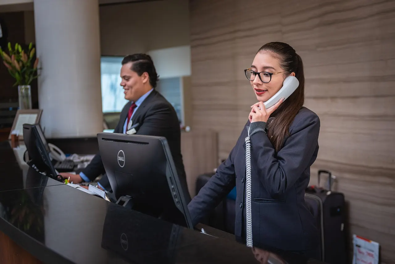 Nhân viên văn phòng nghe điện thoại tại bàn làm việc