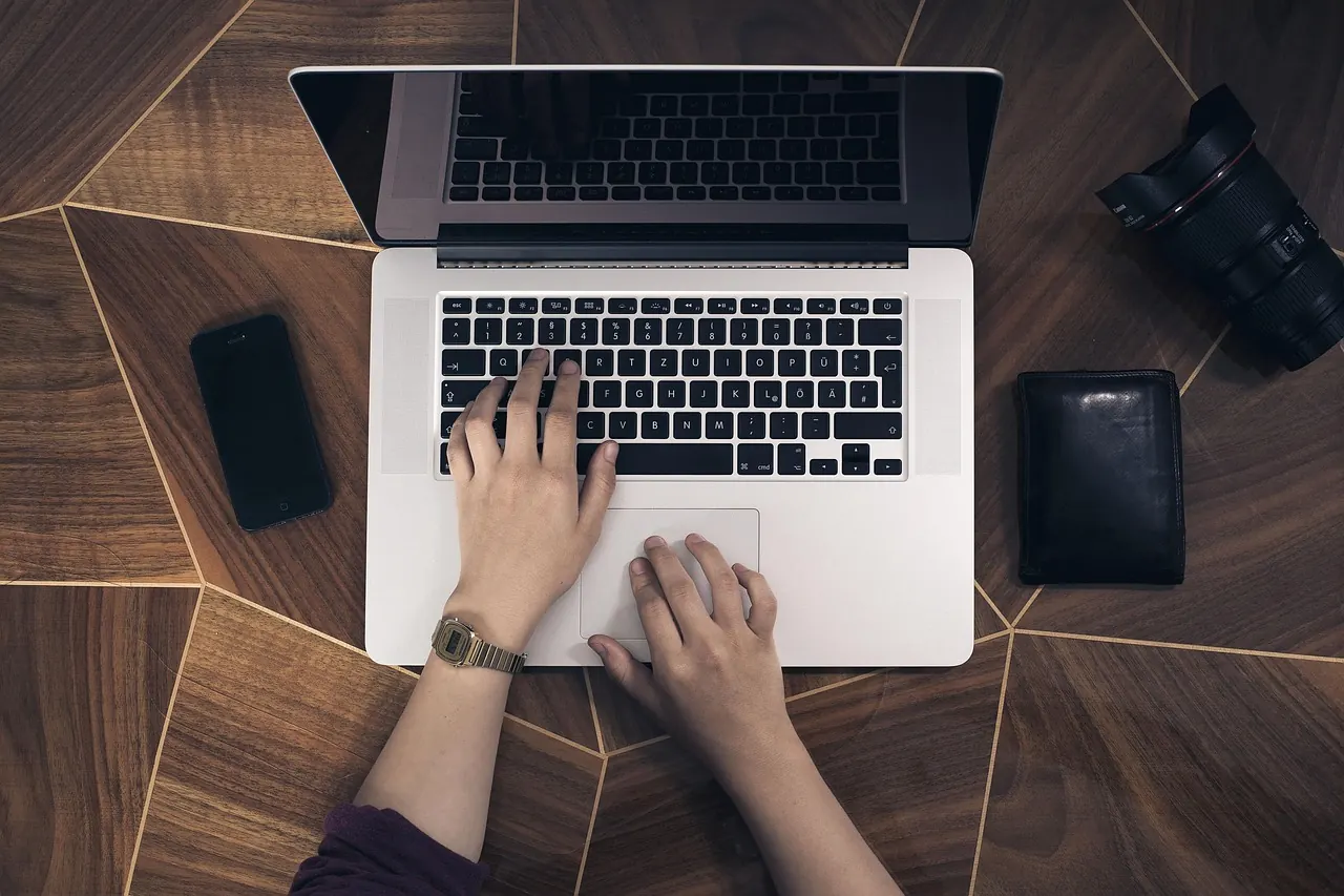Nhìn từ trên xuống đôi tay làm việc trên laptop