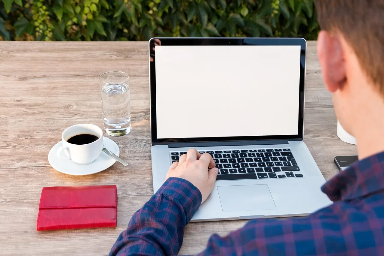 Người đàn ông làm việc với laptop tại quán cà phê