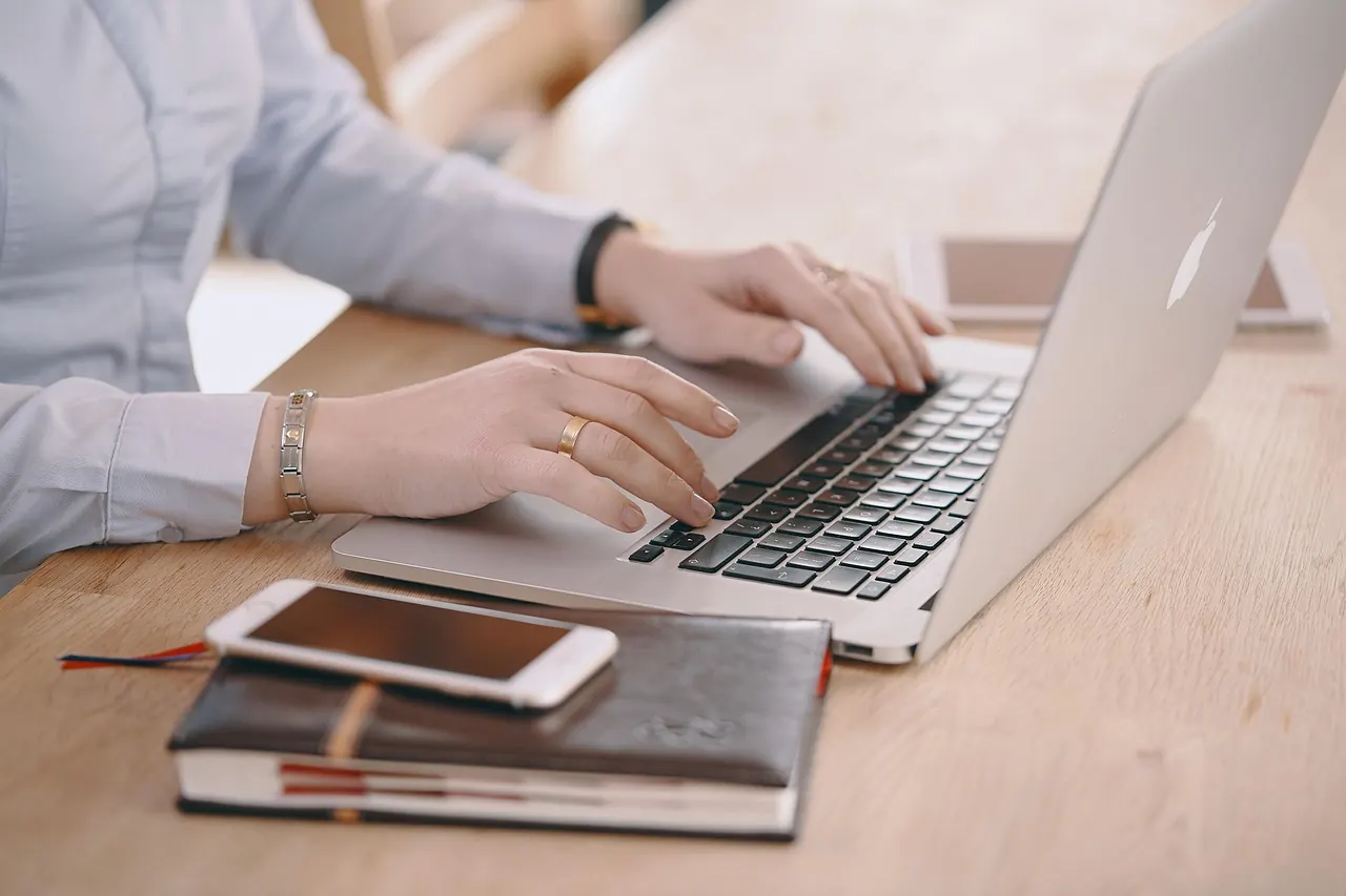 Laptop, điện thoại và sổ tay trên bàn làm việc gọn gàng