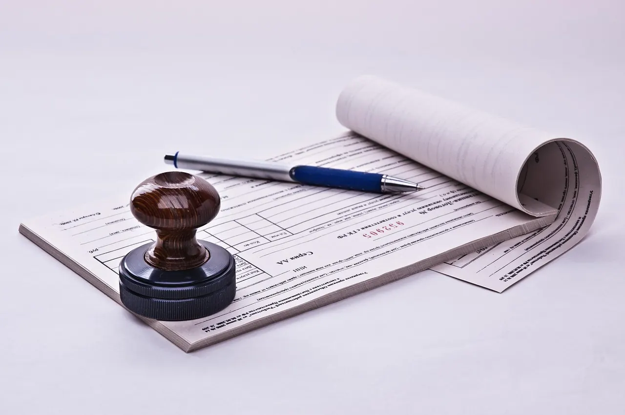 Con dấu, bút ký và tập giấy tờ trên bàn làm việc