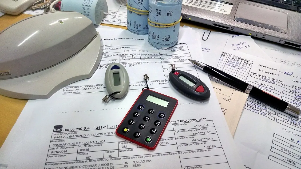 Máy tính, chuột và tờ khai trên bàn làm việc nhìn từ trên